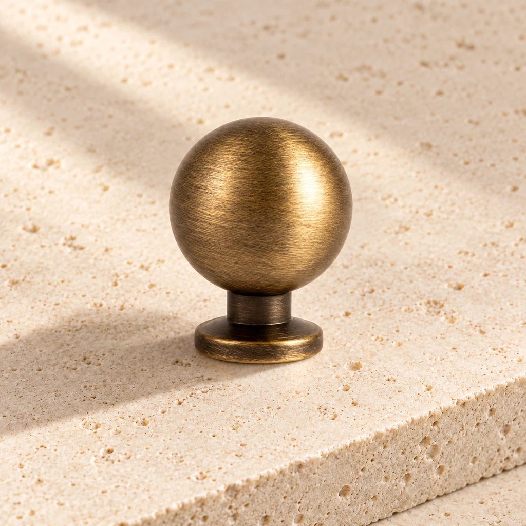 antique brass baluster ball knob limestone on pale limestone.
