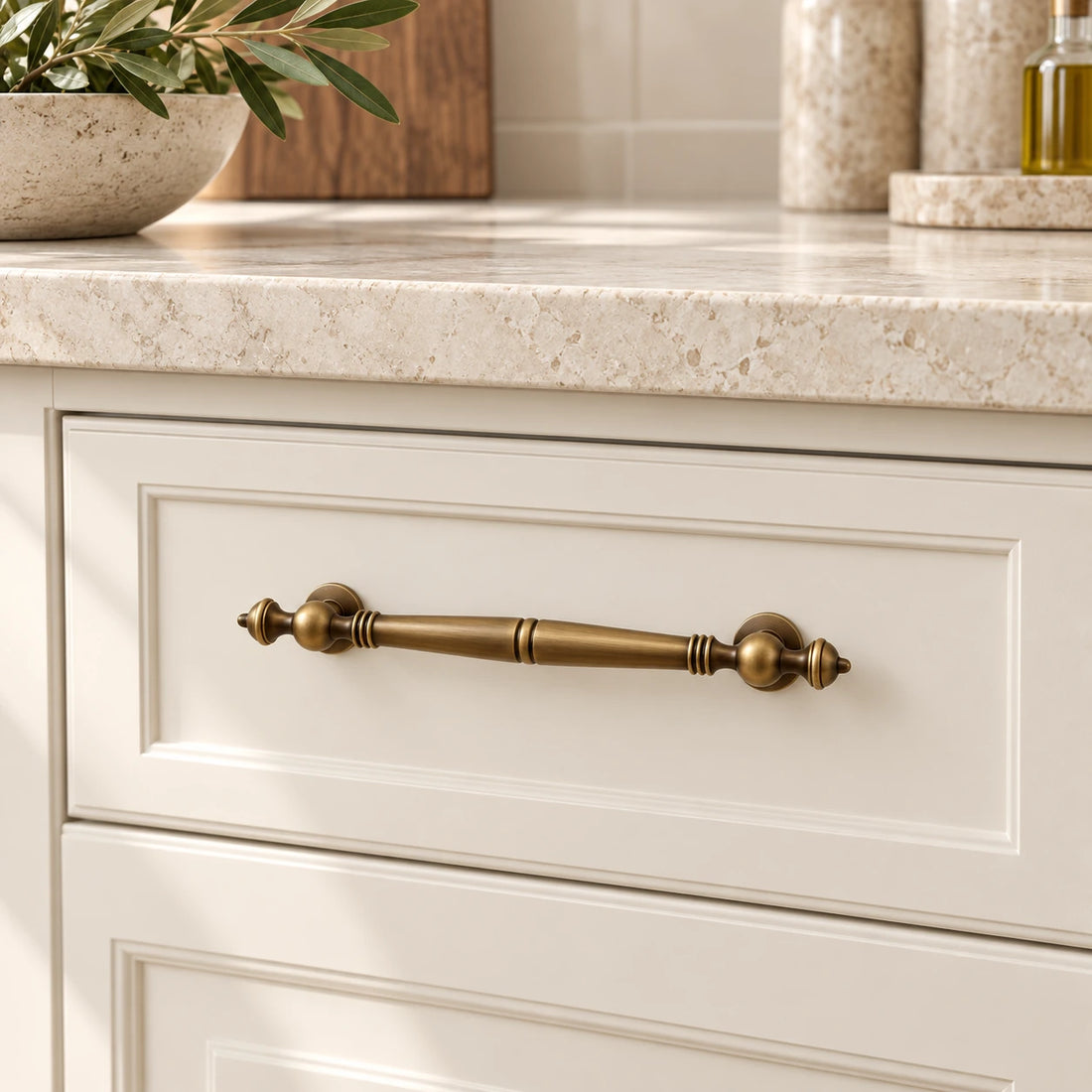 Antique brass baluster cabinet pulls on warm ivory limestone