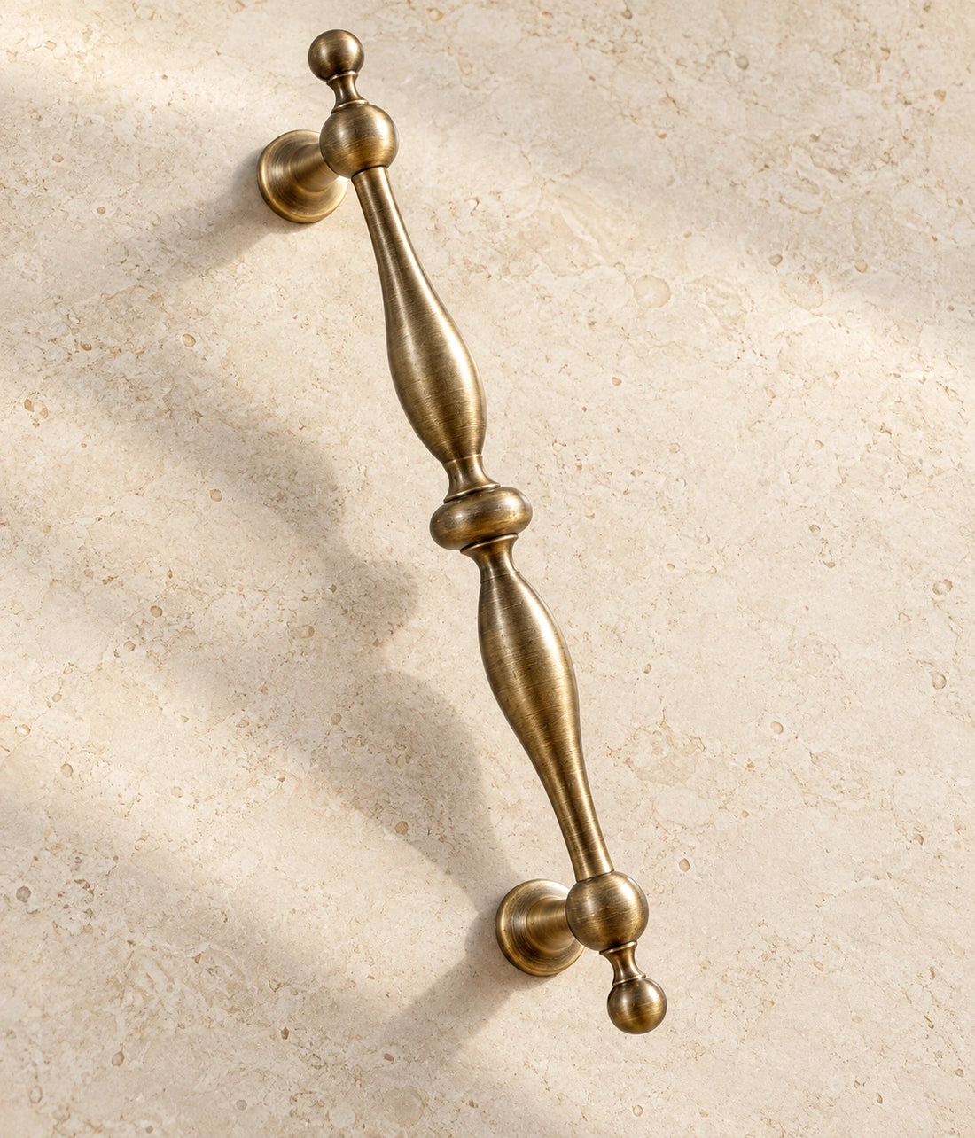 Antique Brass Baluster Cabinet Pulls & Ball Knobs on warm ivory limestone