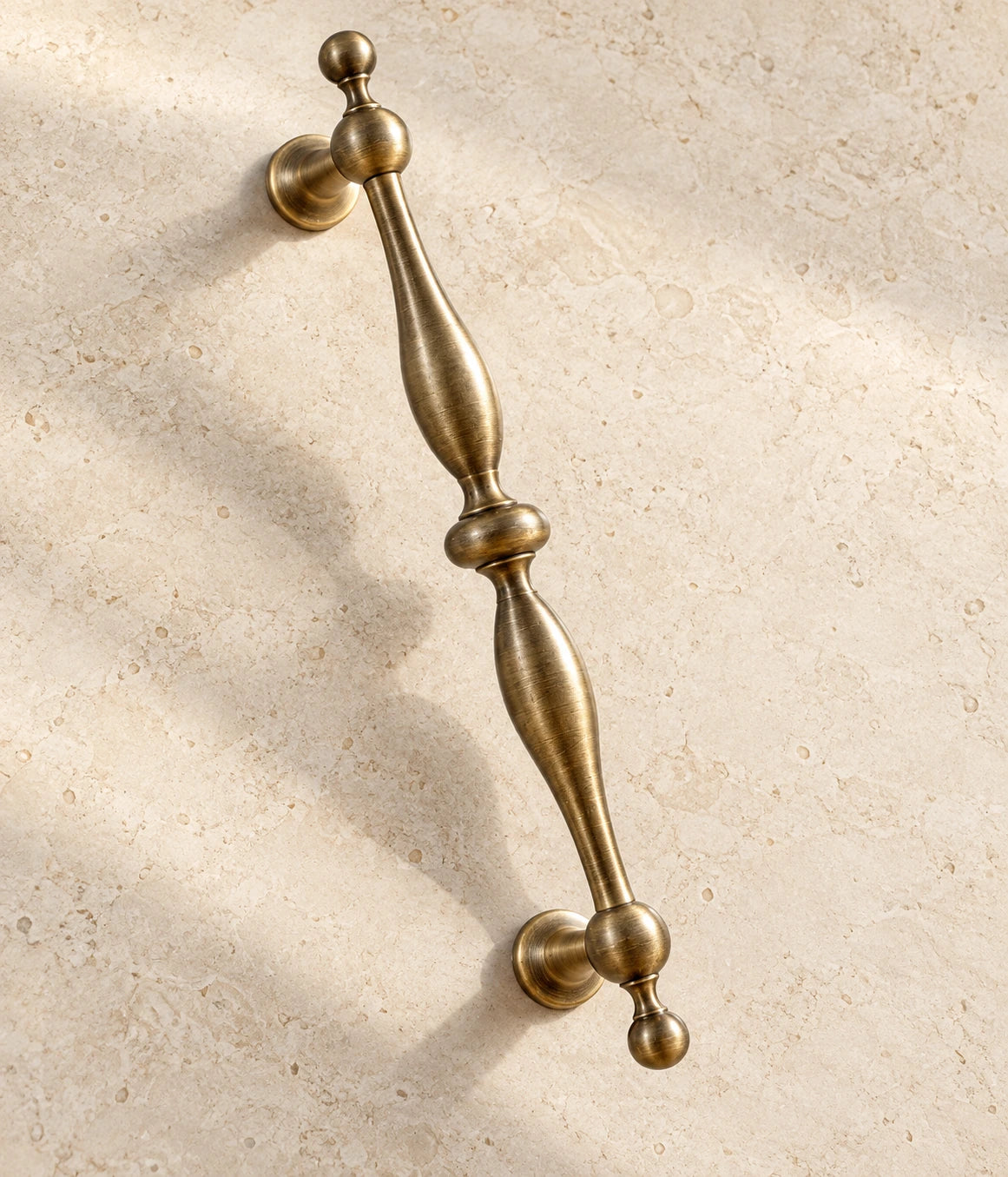 Antique Brass Baluster Cabinet Pulls & Ball Knobs on warm ivory limestone