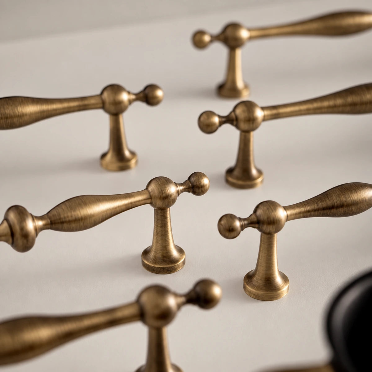 Close-up of baluster cabinet pull grips, rounded finials and tapered mounting posts