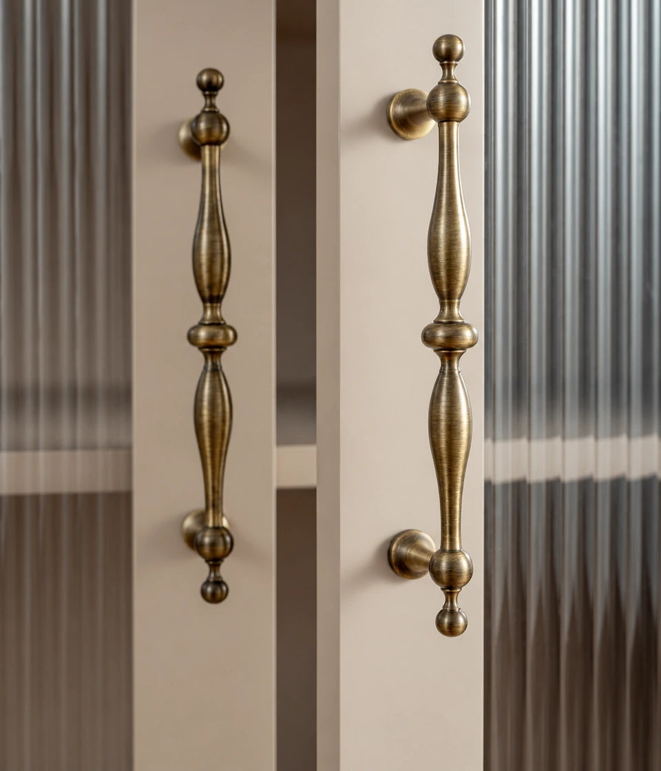 Antique brass baluster cabinet pulls installed on glass cabinet doors