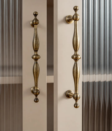 Antique brass baluster cabinet pulls installed on glass cabinet doors