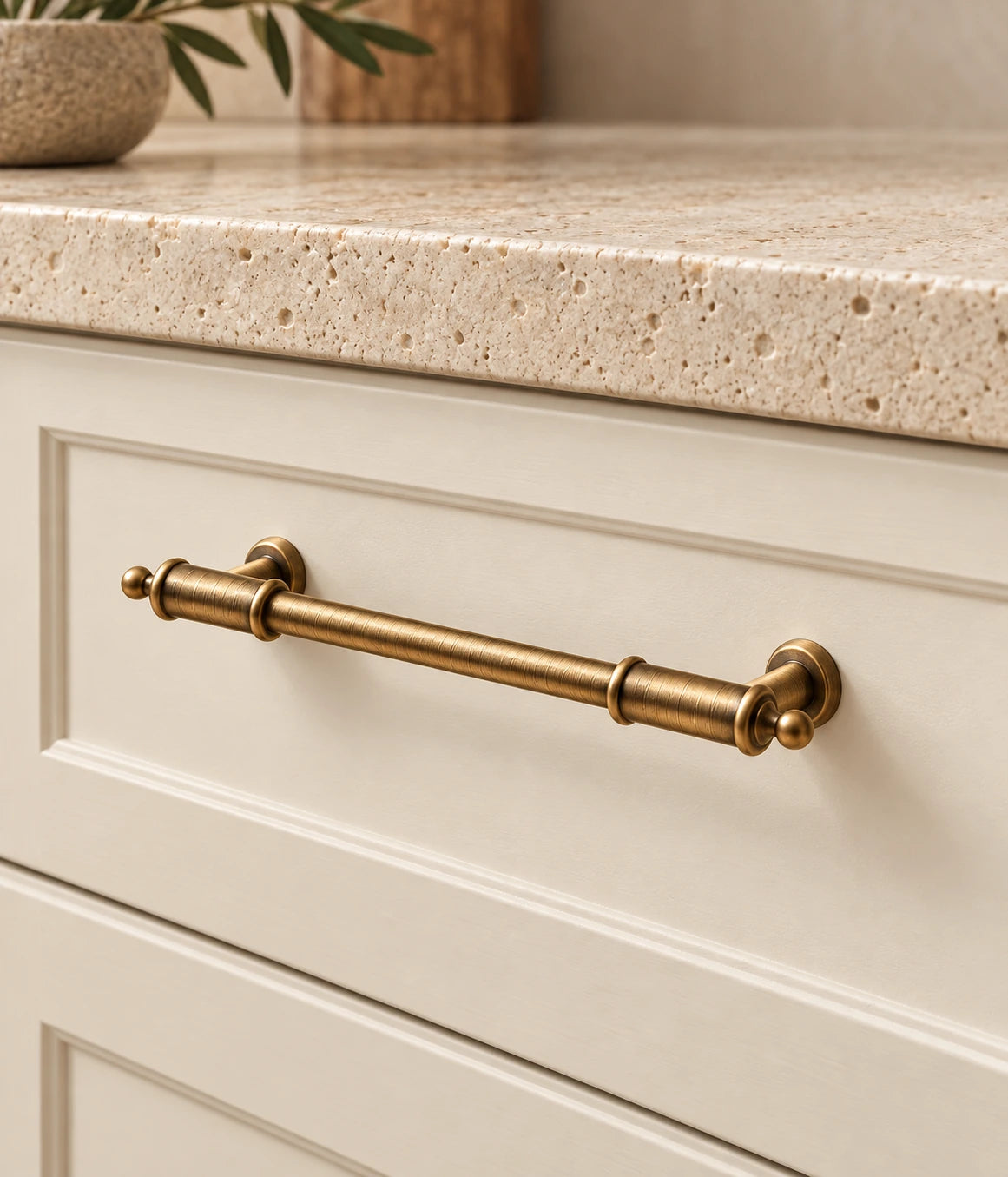 Antique Brass Barrel-Collar Cabinet Pulls & T-Knob installed on an ivory cabinet drawer