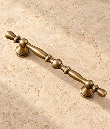 Antique Brass Beaded Cabinet Pulls on warm ivory limestone