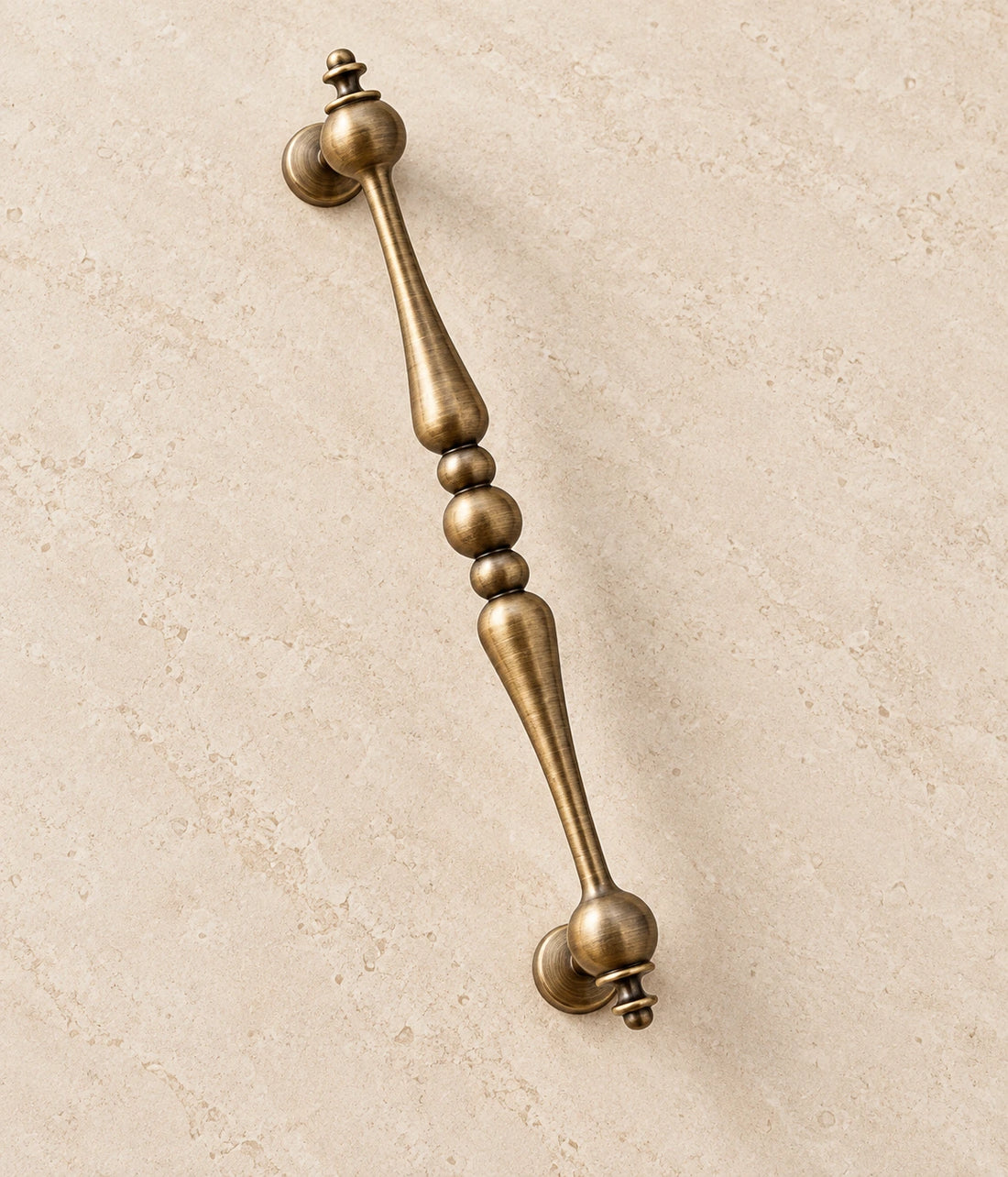 Antique Brass Beaded-Center Cabinet Pulls on warm ivory limestone
