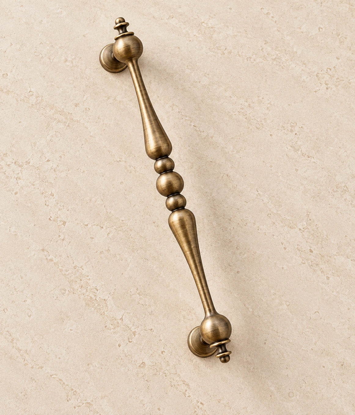 Antique Brass Beaded-Center Cabinet Pulls on warm ivory limestone