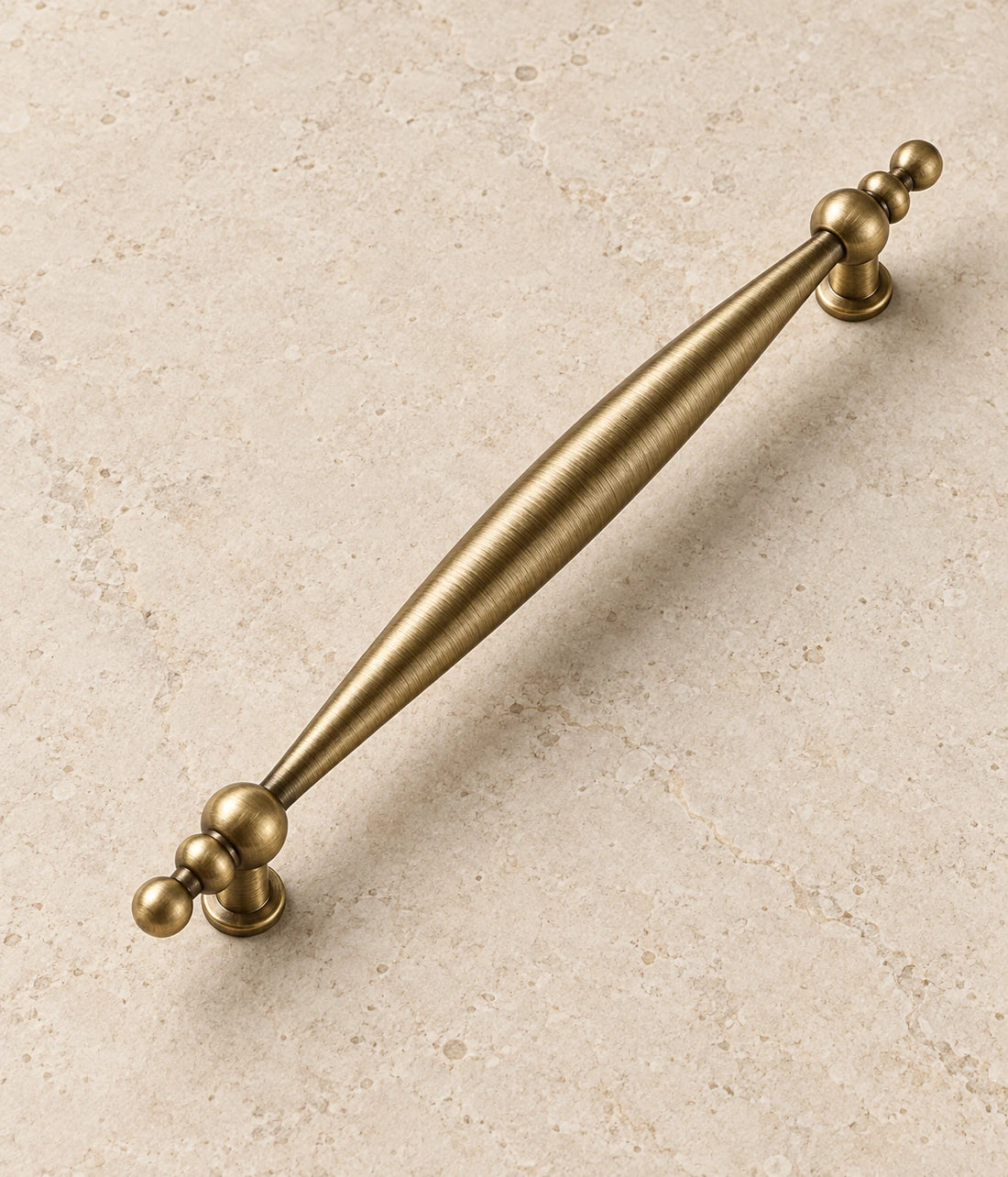 Antique Brass Beaded-End Cabinet Pulls on warm ivory limestone