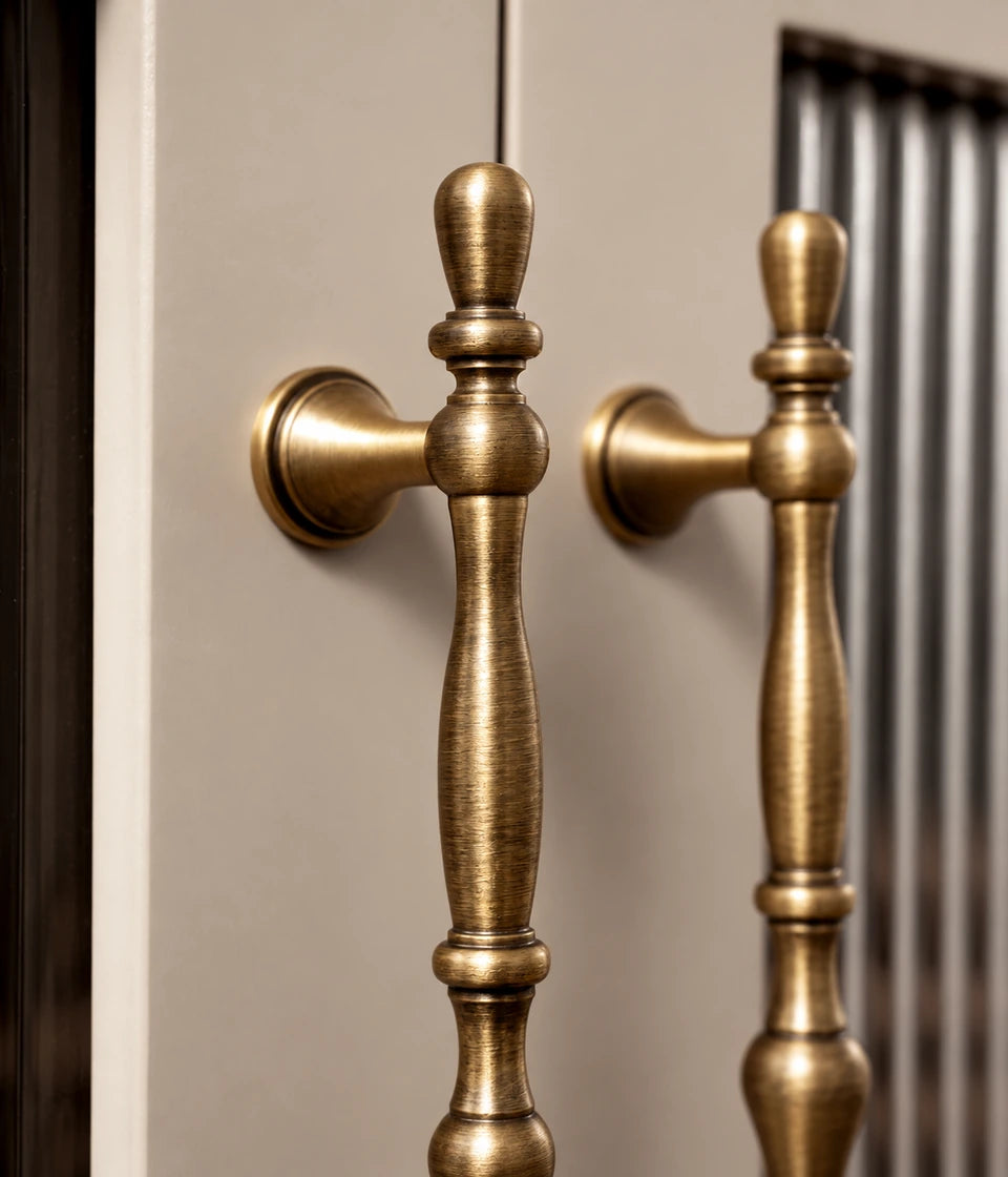 Four antique brass beaded cabinet pulls arranged on wood with gold fabric