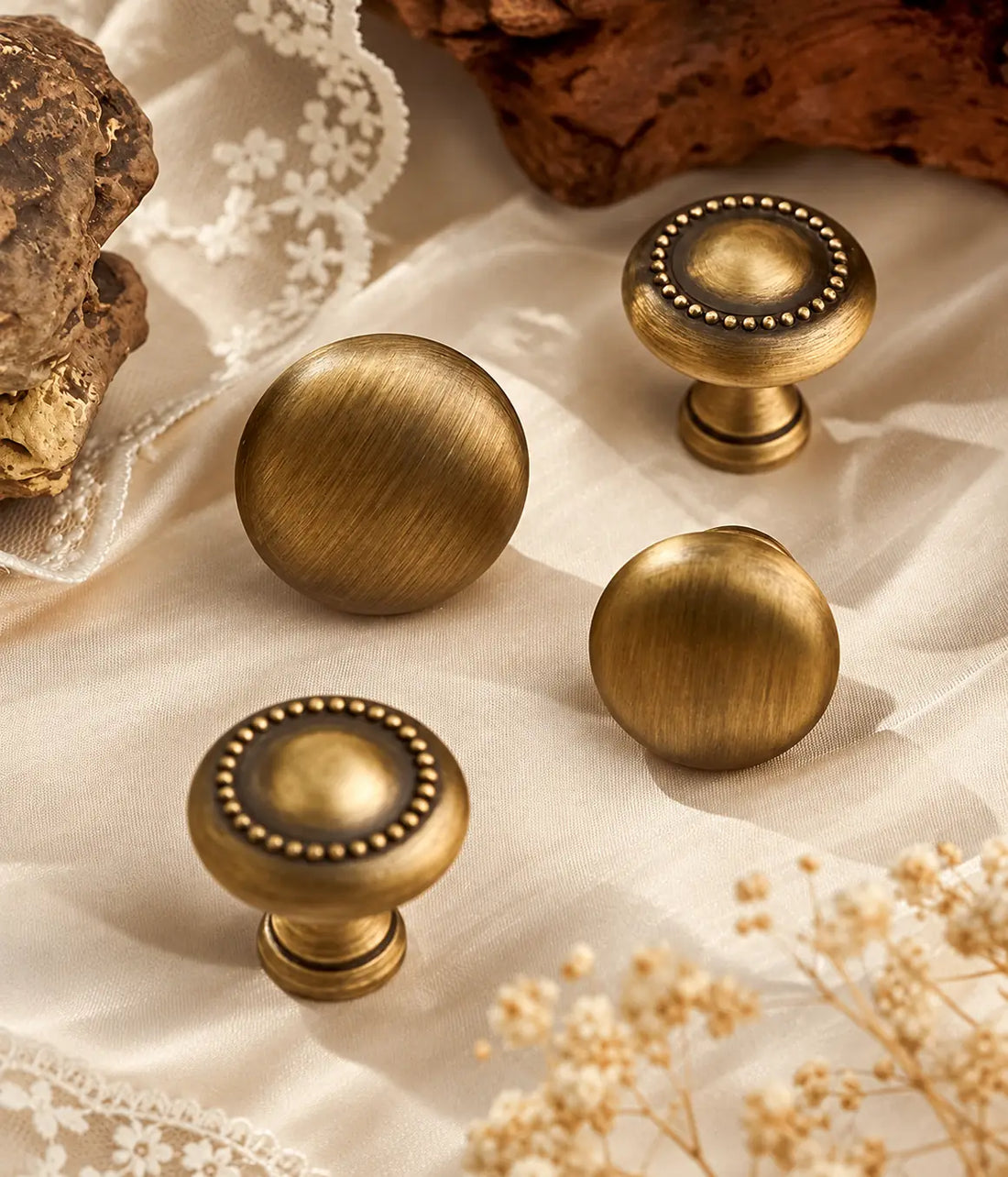 Antique brass beaded and smooth round cabinet knobs on cream fabric