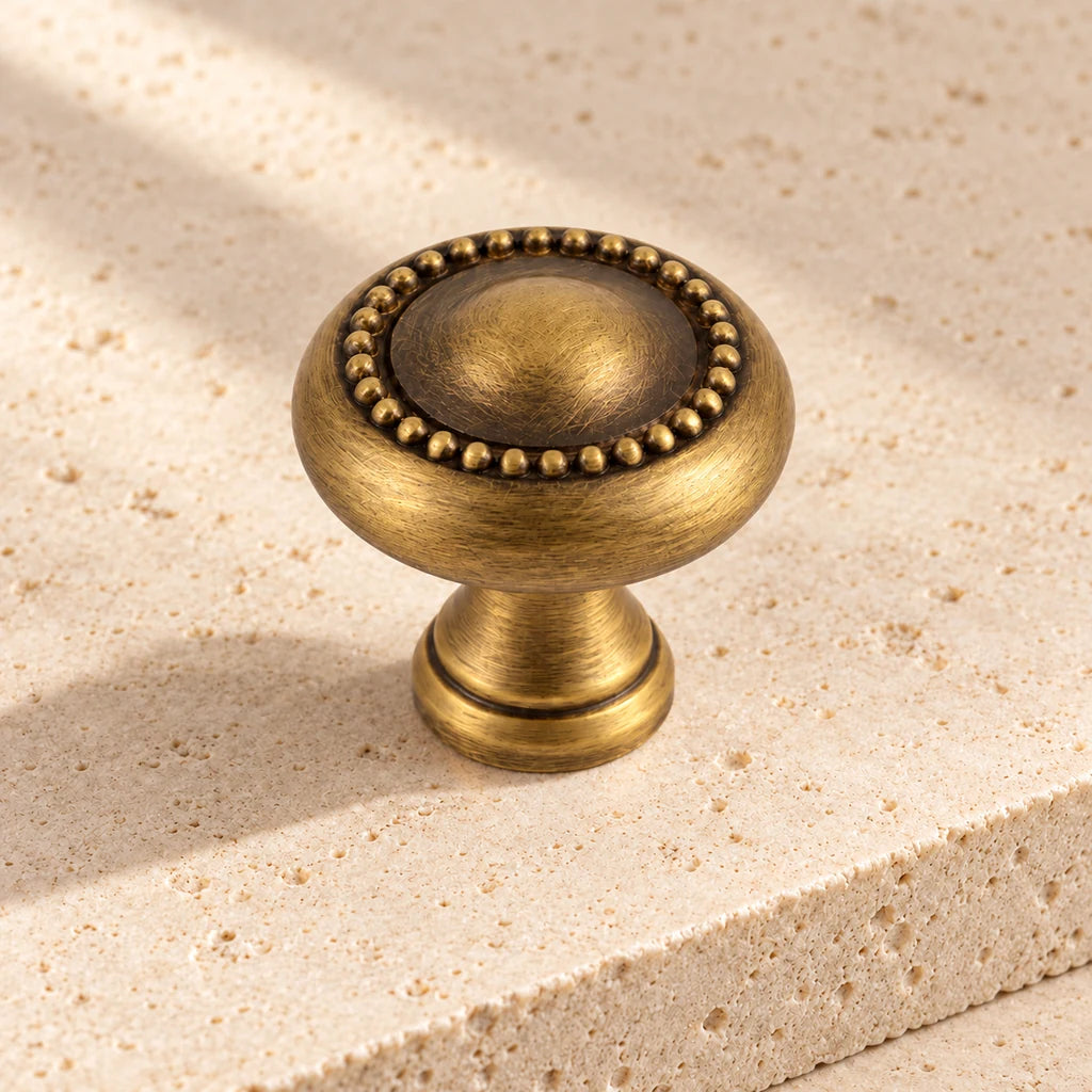 antique brass beaded spindle cup knob limestone on pale limestone.
