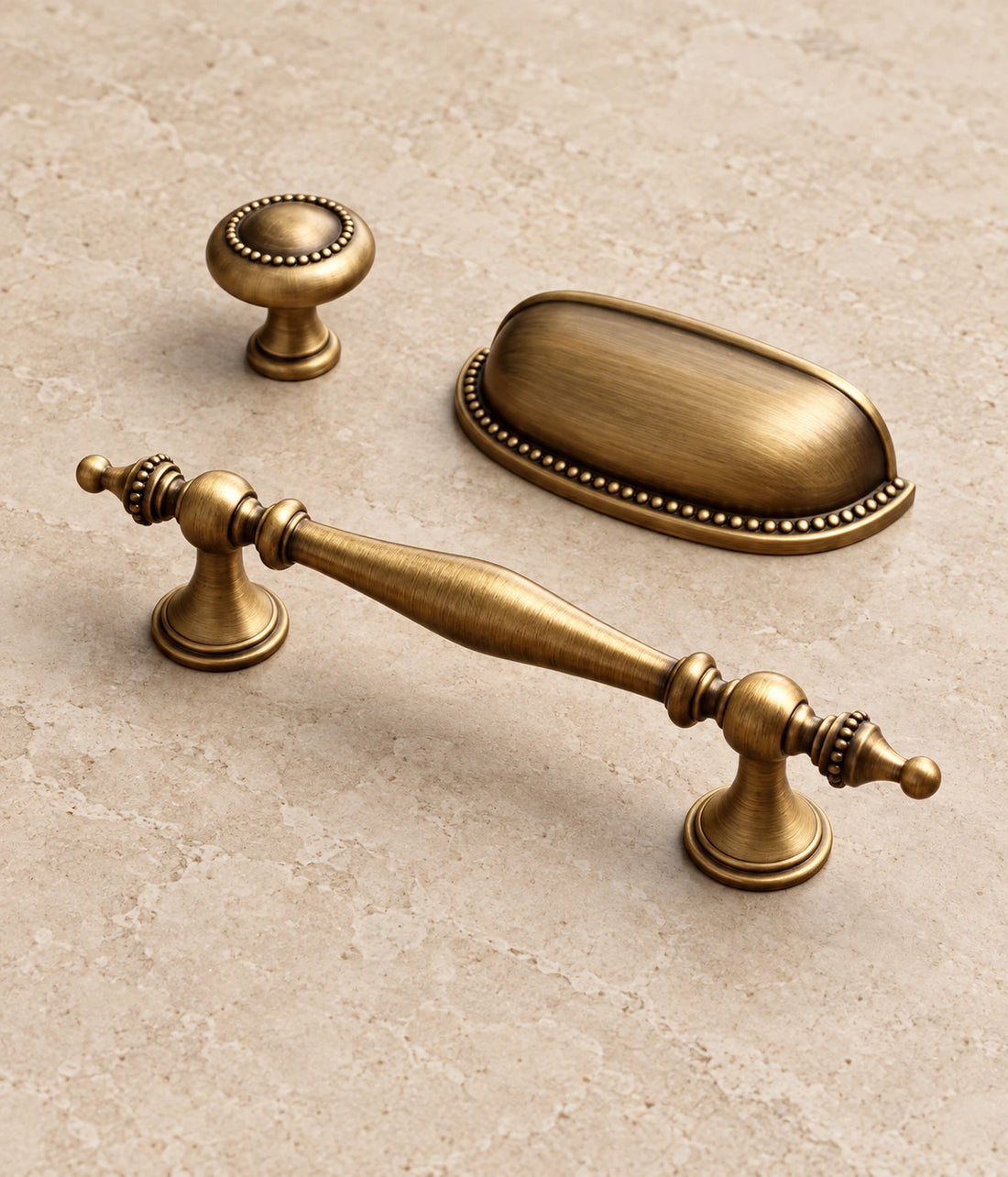 Antique Brass Beaded Spindle Pulls, Cup Pull & Knob on warm ivory limestone