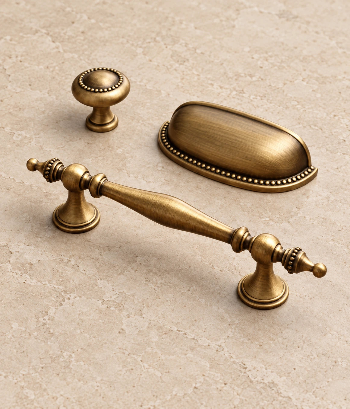 Antique Brass Beaded Spindle Pulls, Cup Pull & Knob on warm ivory limestone