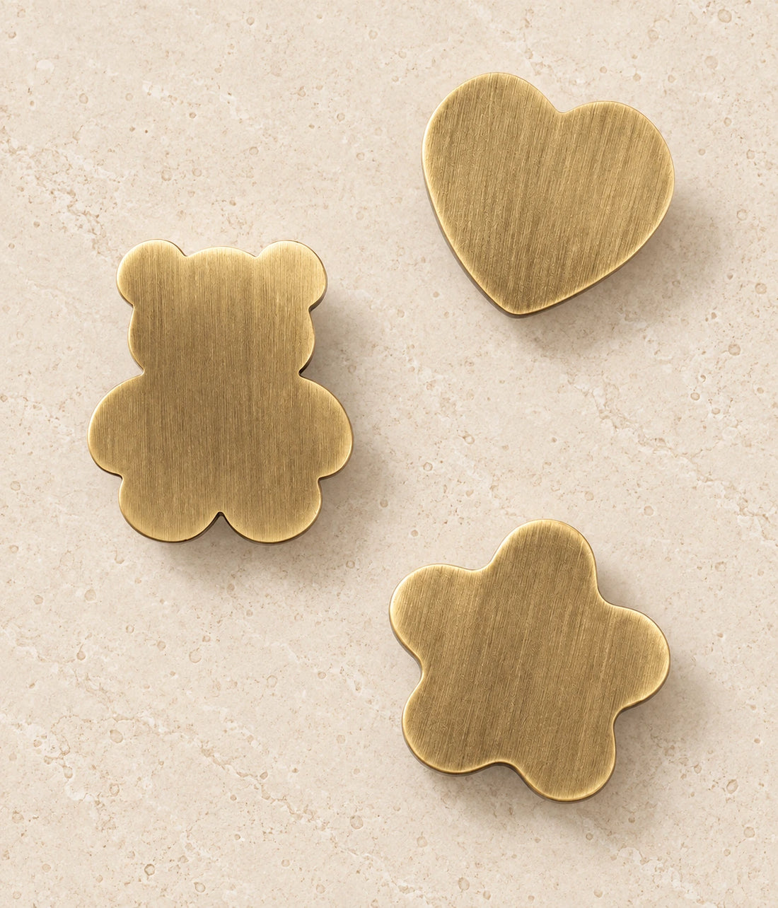 Antique Brass Bear, Heart & Star Cabinet Knobs on warm ivory limestone