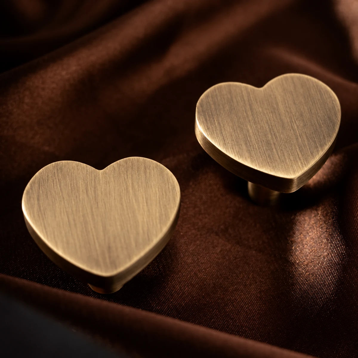 Close-up of brushed brass heart cabinet knobs