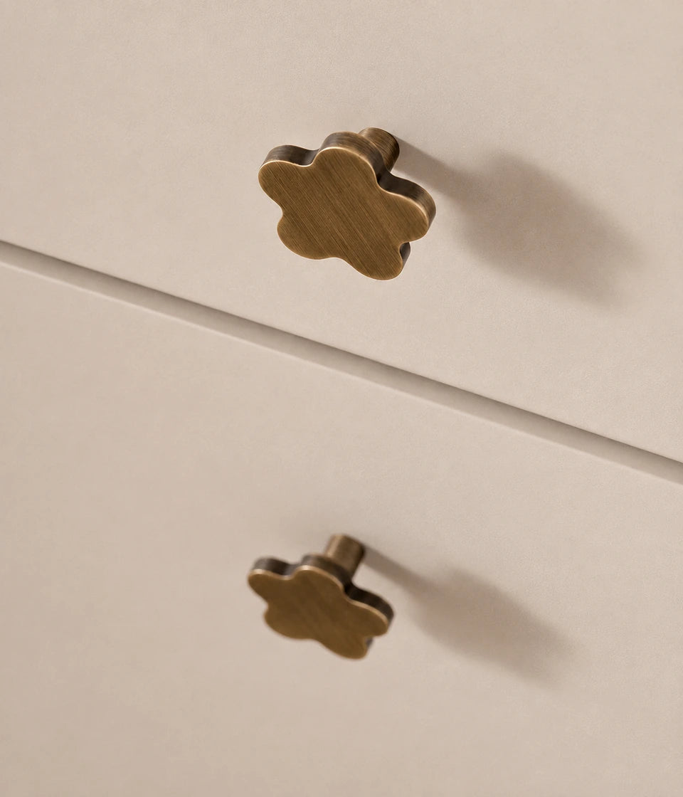 Rounded star cabinet knobs installed on cream drawers