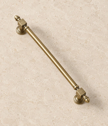 Antique Brass Block-End Cabinet Pulls & T-Knob on warm ivory limestone