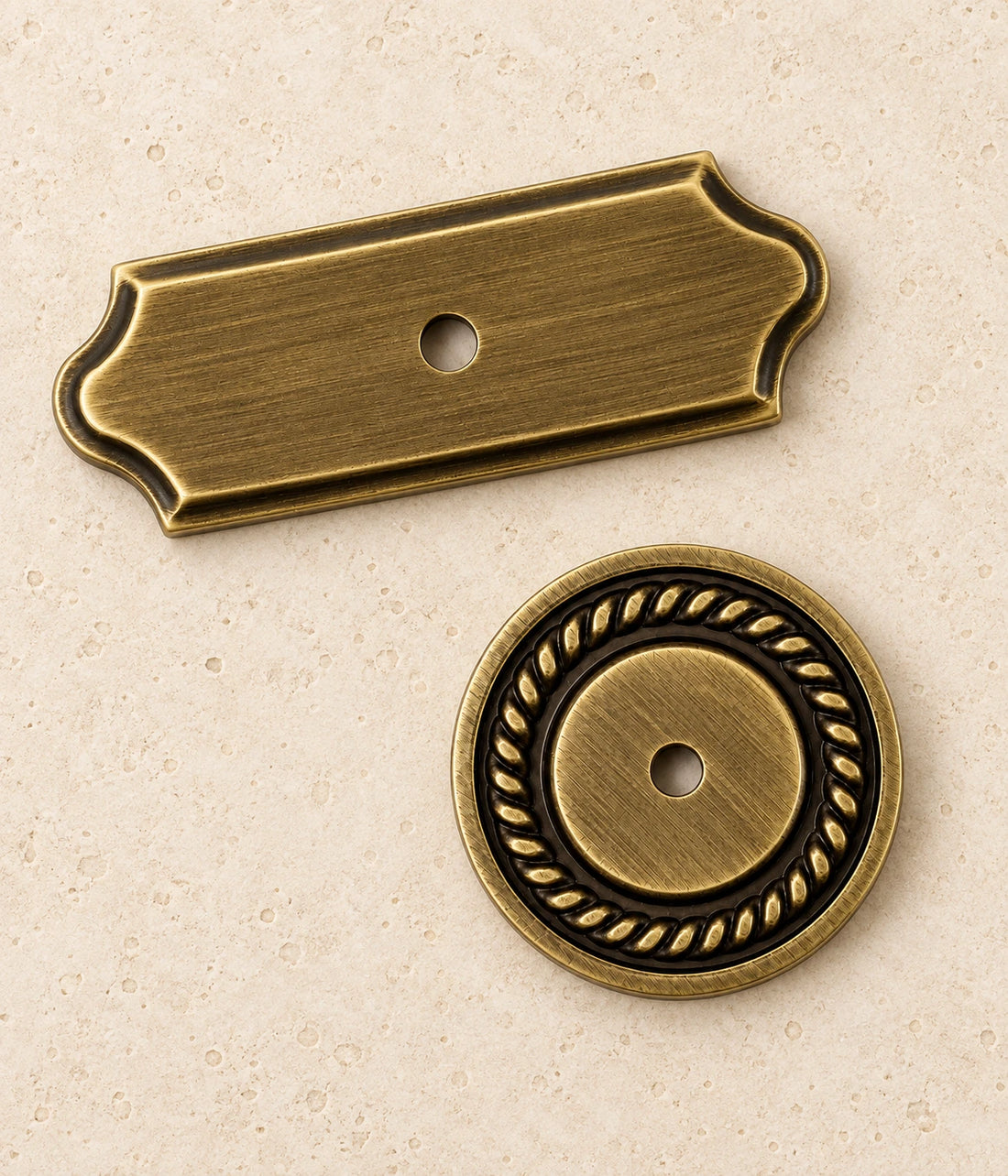 Antique Brass Cabinet Knob Backplates on warm limestone