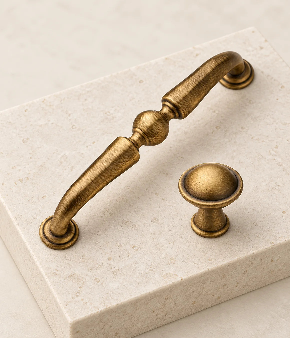Close view of solid brass center-ball cabinet pull and raised-rim domed knob