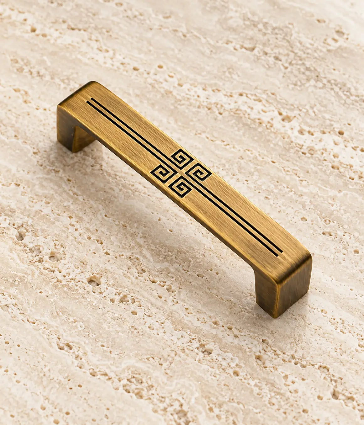 Detail of the four square spirals and brushed antique brass surface on the cabinet pull