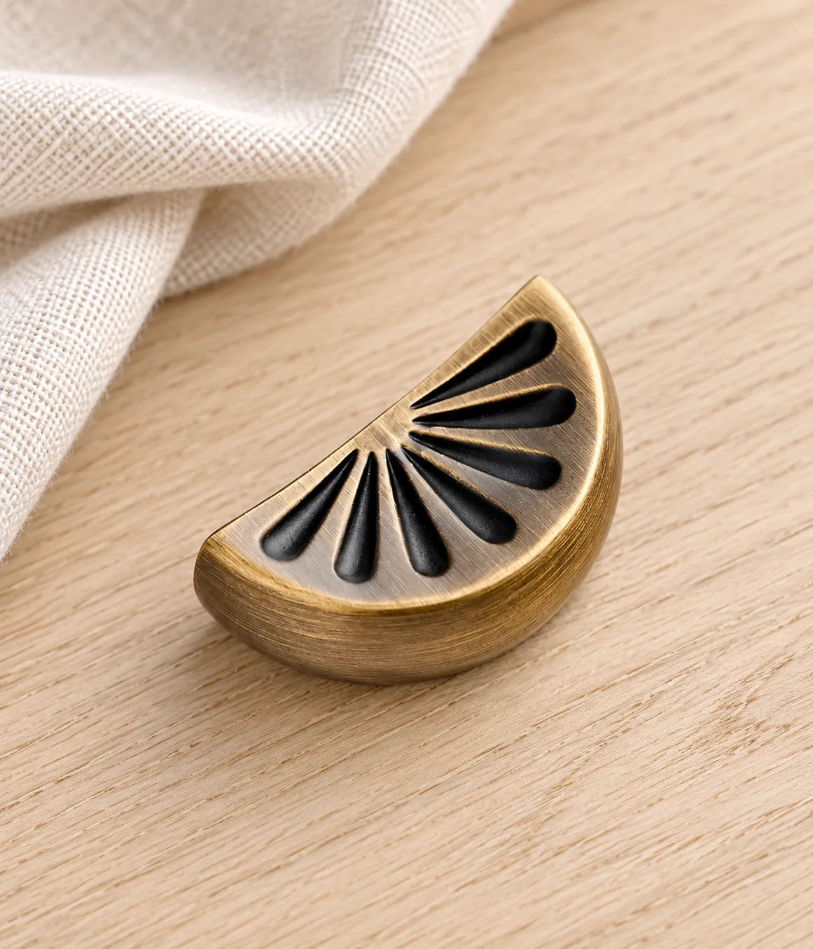 Citrus slice brass cabinet knob styled on pale oak and ivory linen
