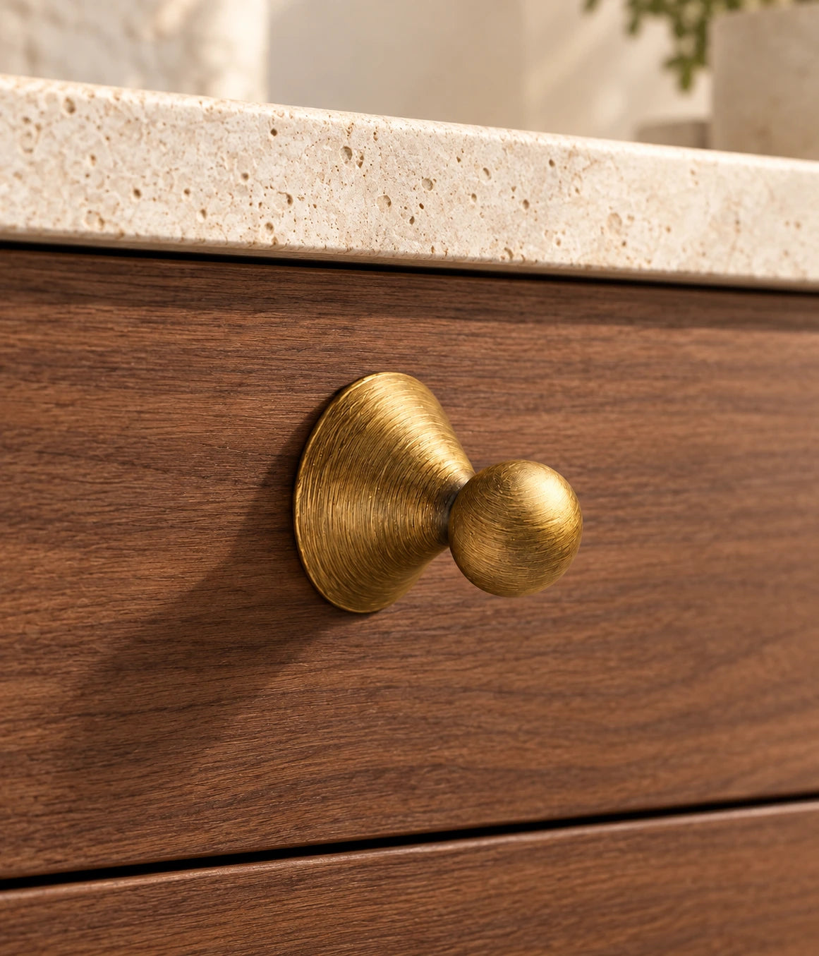 Antique Brass Conical-Base Ball Cabinet Knob installed on a walnut cabinet drawer