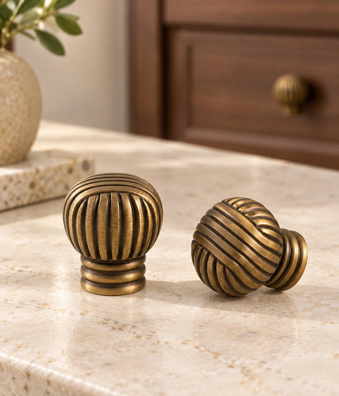 Antique brass ball knobs on a stone console beside walnut cabinetry