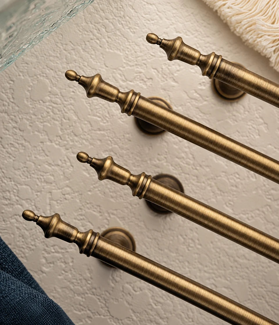 Antique brass crown cabinet pulls showing turned finials and brushed finish