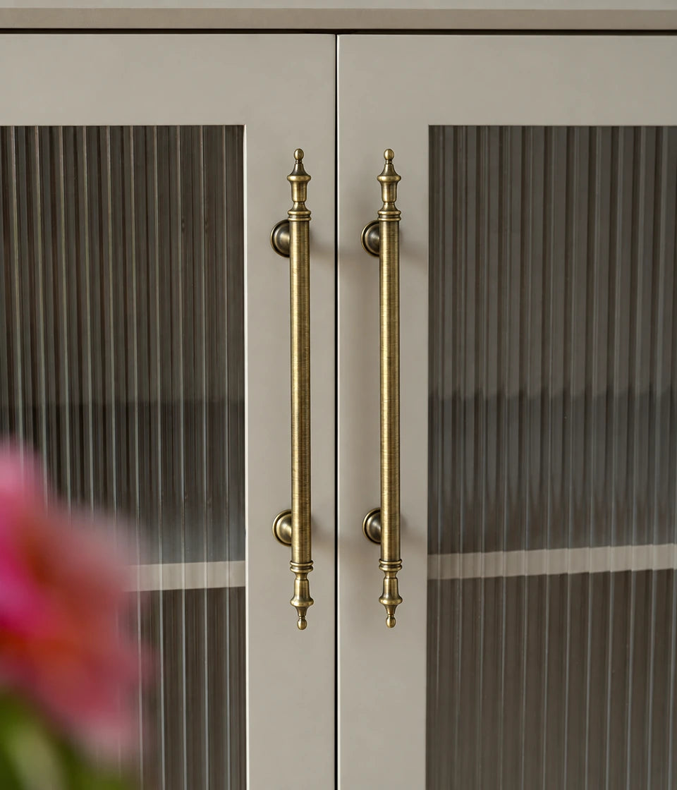 Antique brass crown cabinet pulls installed on ribbed glass cabinet doors