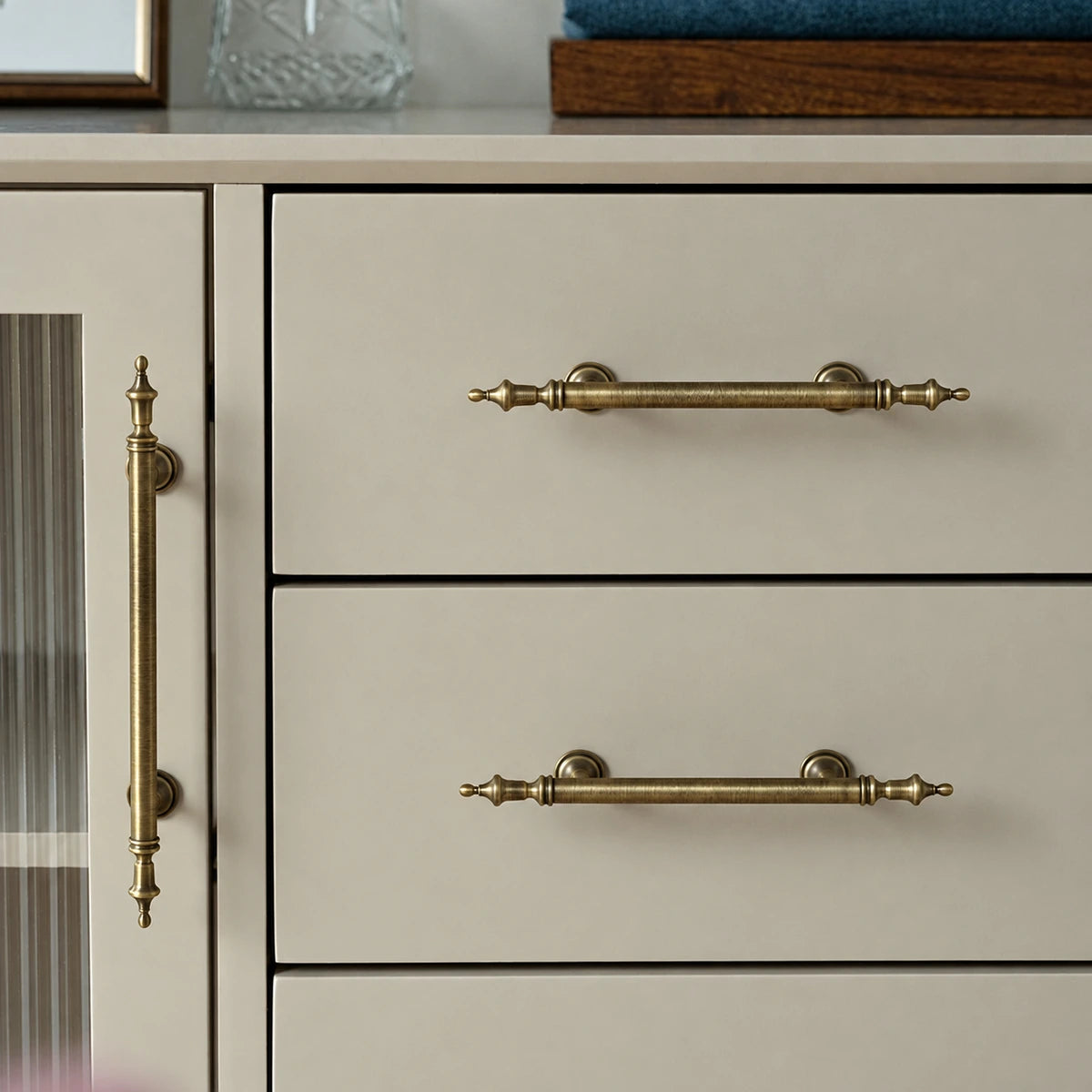 Antique brass crown pulls fitted to drawers and a cabinet door