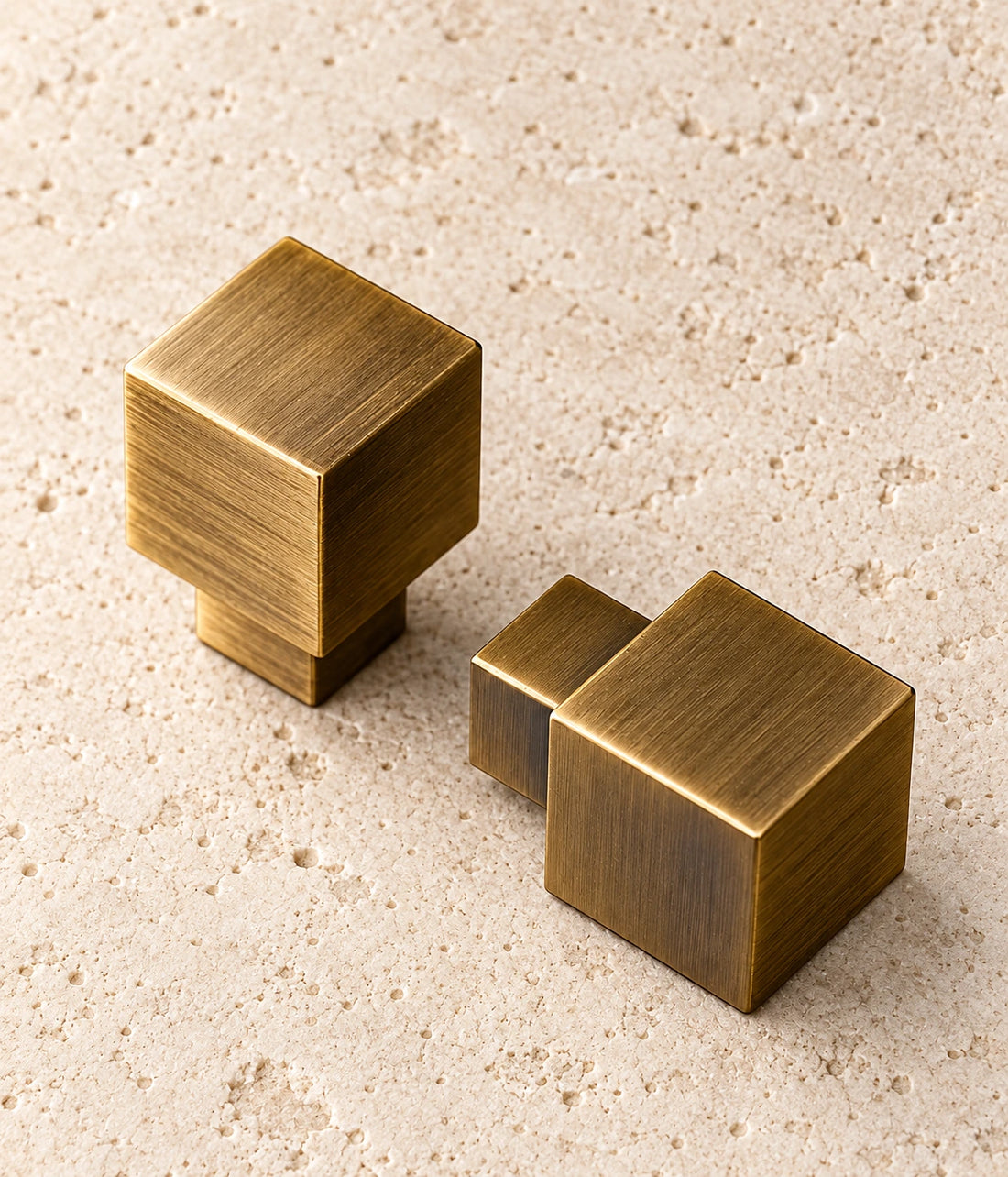 Antique Brass Cube Cabinet Knob on warm limestone