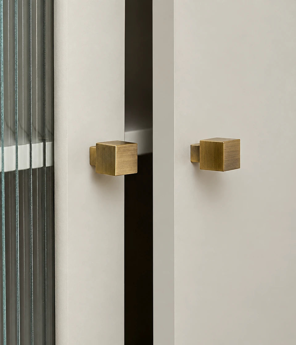 Antique brass cube cabinet knobs fitted to light cabinet doors