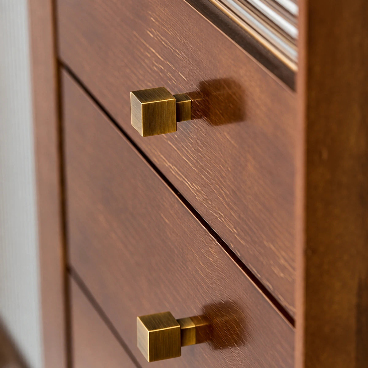 Square antique brass knobs fitted to wooden drawers
