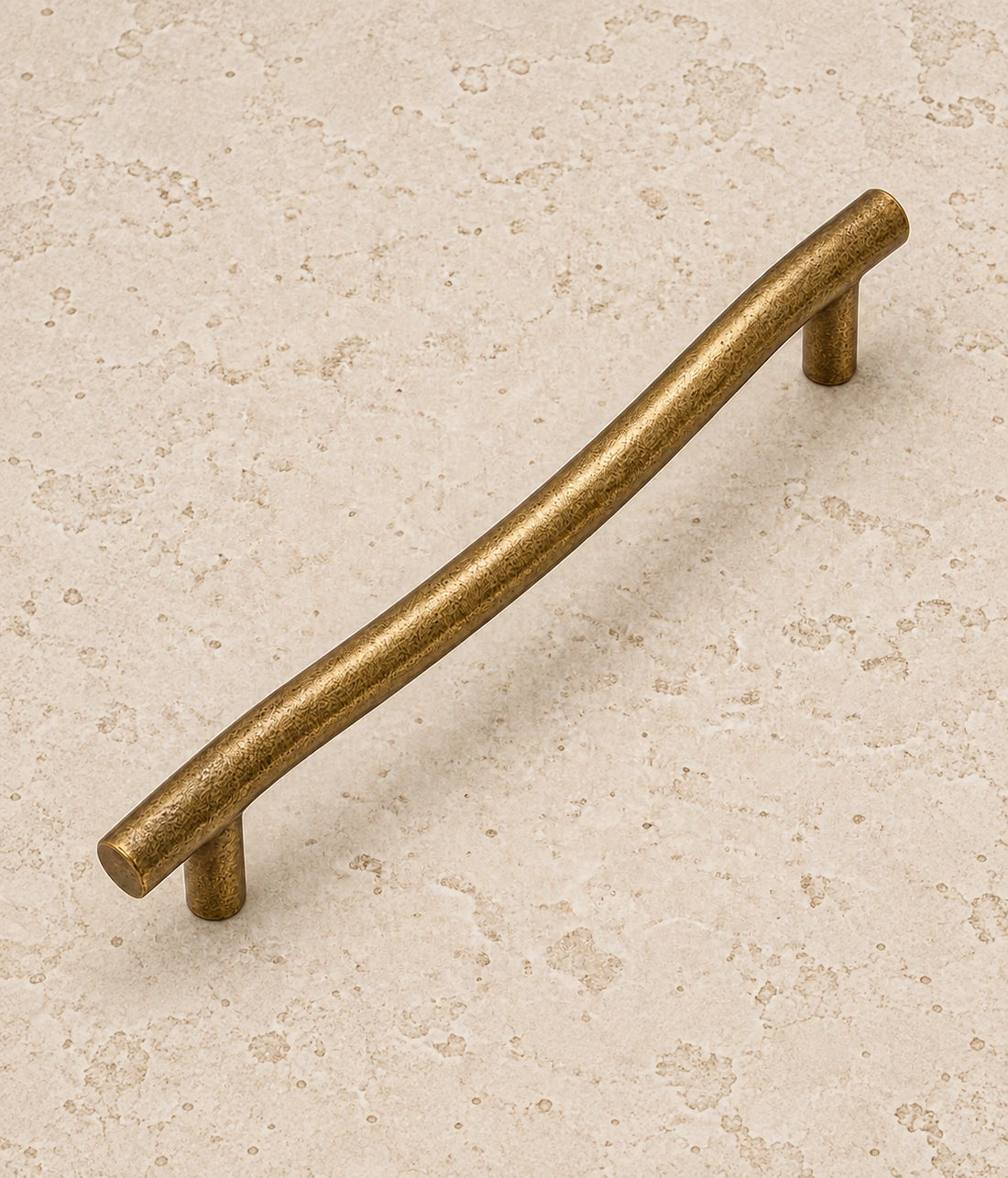 Antique Brass Curved Cabinet Pulls on warm limestone