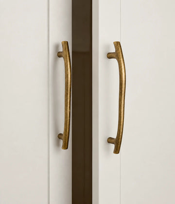 Antique brass curved cabinet pulls mounted on cabinet doors