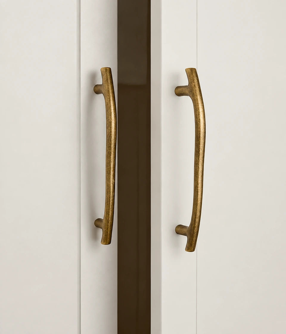 Antique brass curved cabinet pulls mounted on cabinet doors