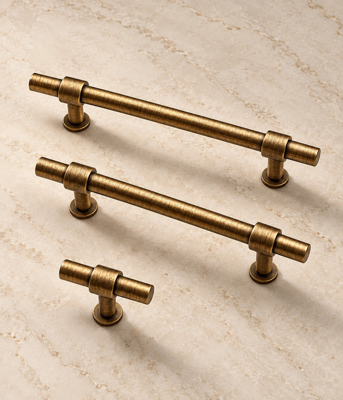 Antique Brass Cylinder Cabinet Pulls & Knobs on warm ivory limestone