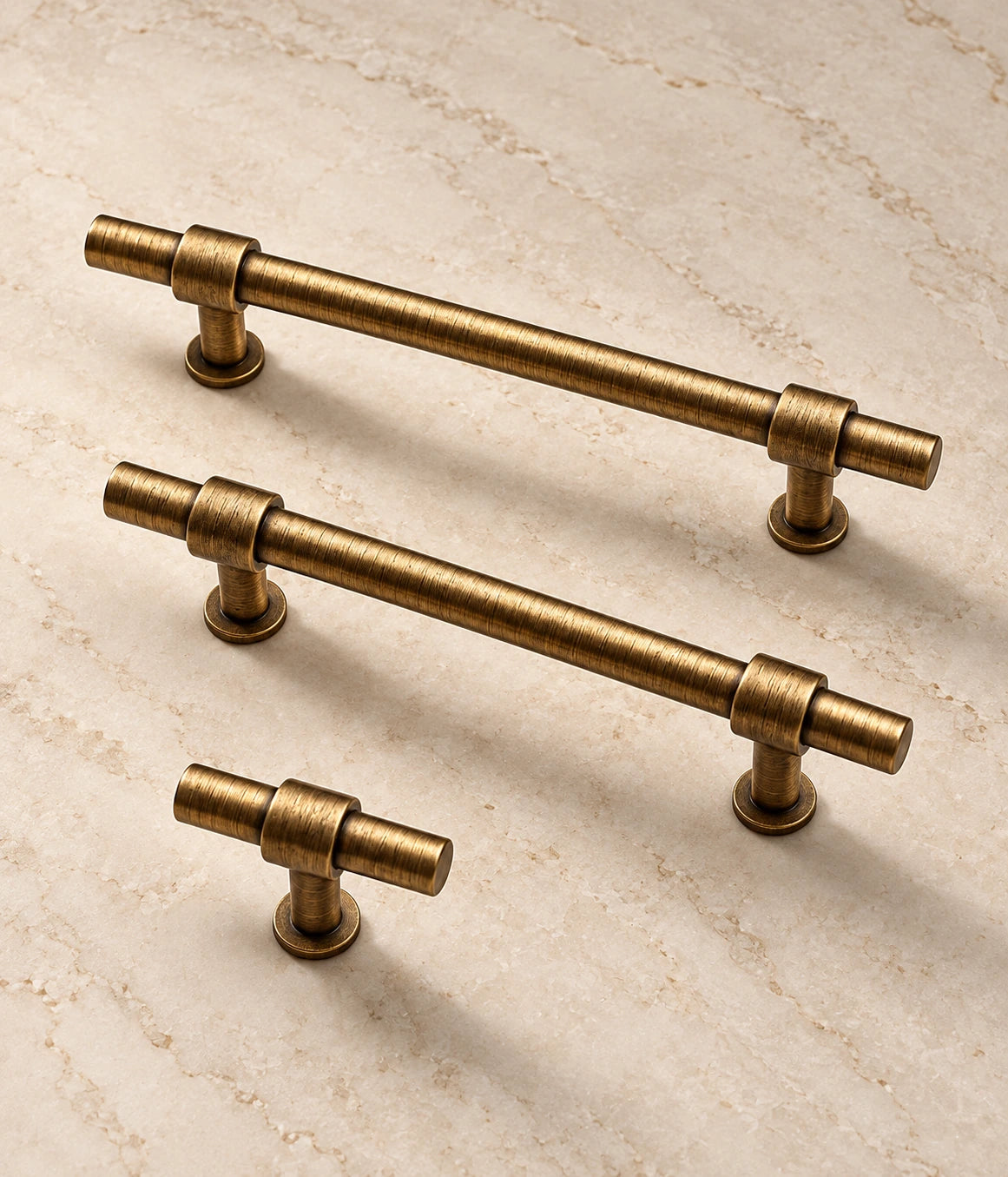 Antique Brass Cylinder Cabinet Pulls & Knobs on warm ivory limestone