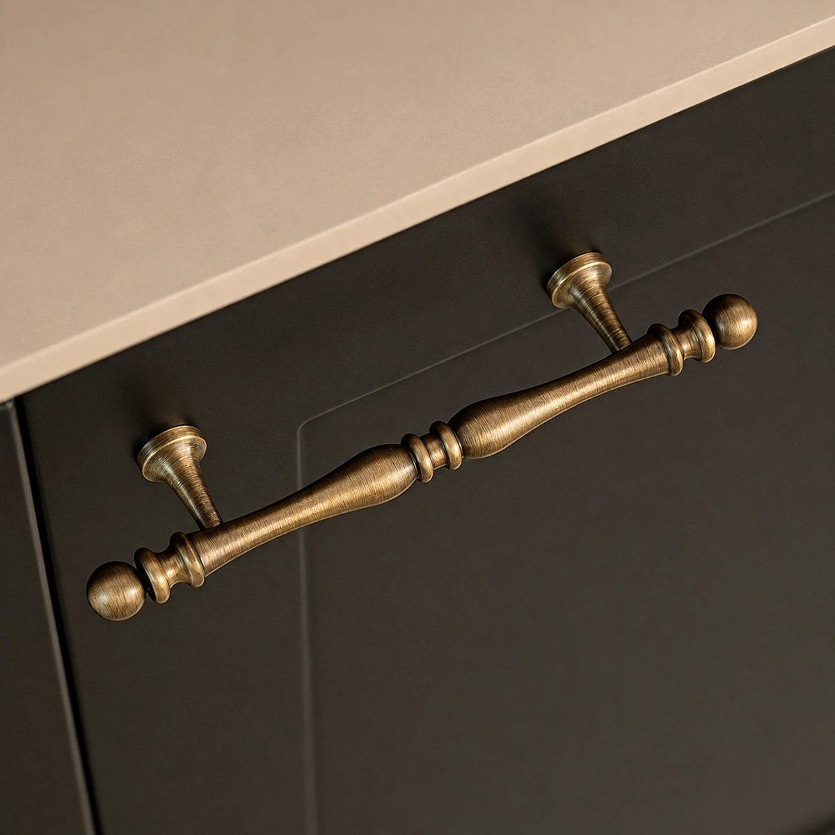 Close-up of a decorative antique brass drawer pull with ball finials