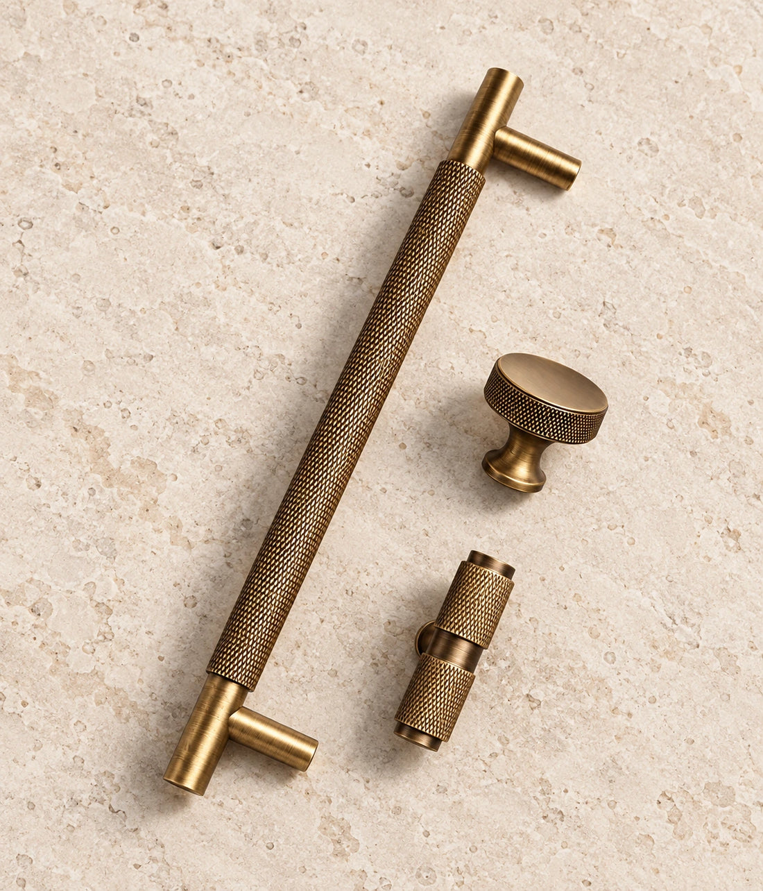 Antique Brass Diamond-Knurled Cabinet Pulls & Knobs on warm ivory limestone