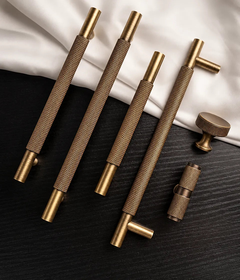 Diamond-knurled antique brass pulls, flared disc knob and T-knob on black wood with cream fabric
