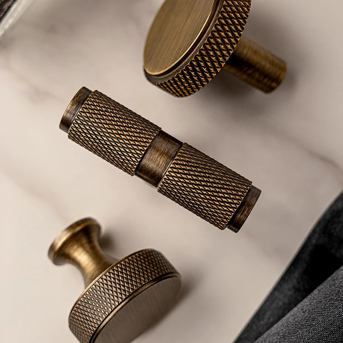 Close-up of antique brass T-knob and disc knobs with diamond-knurled grips
