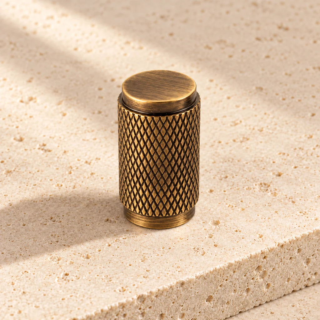 antique brass diamond knurled knob limestone on pale limestone.