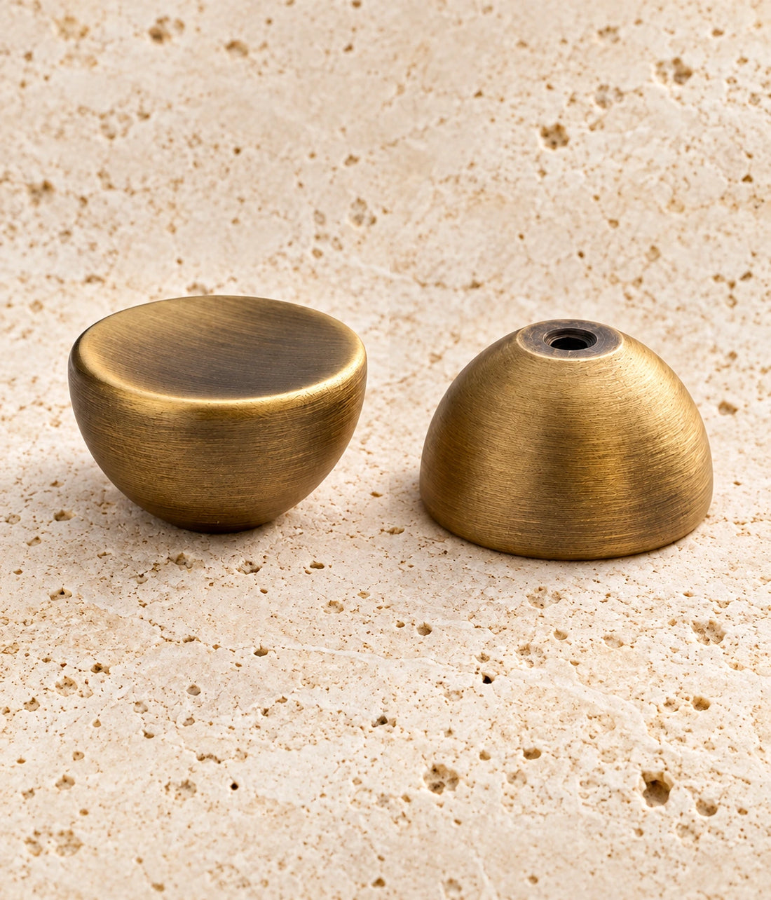 Antique Brass Dished Round Cabinet Knob on warm limestone