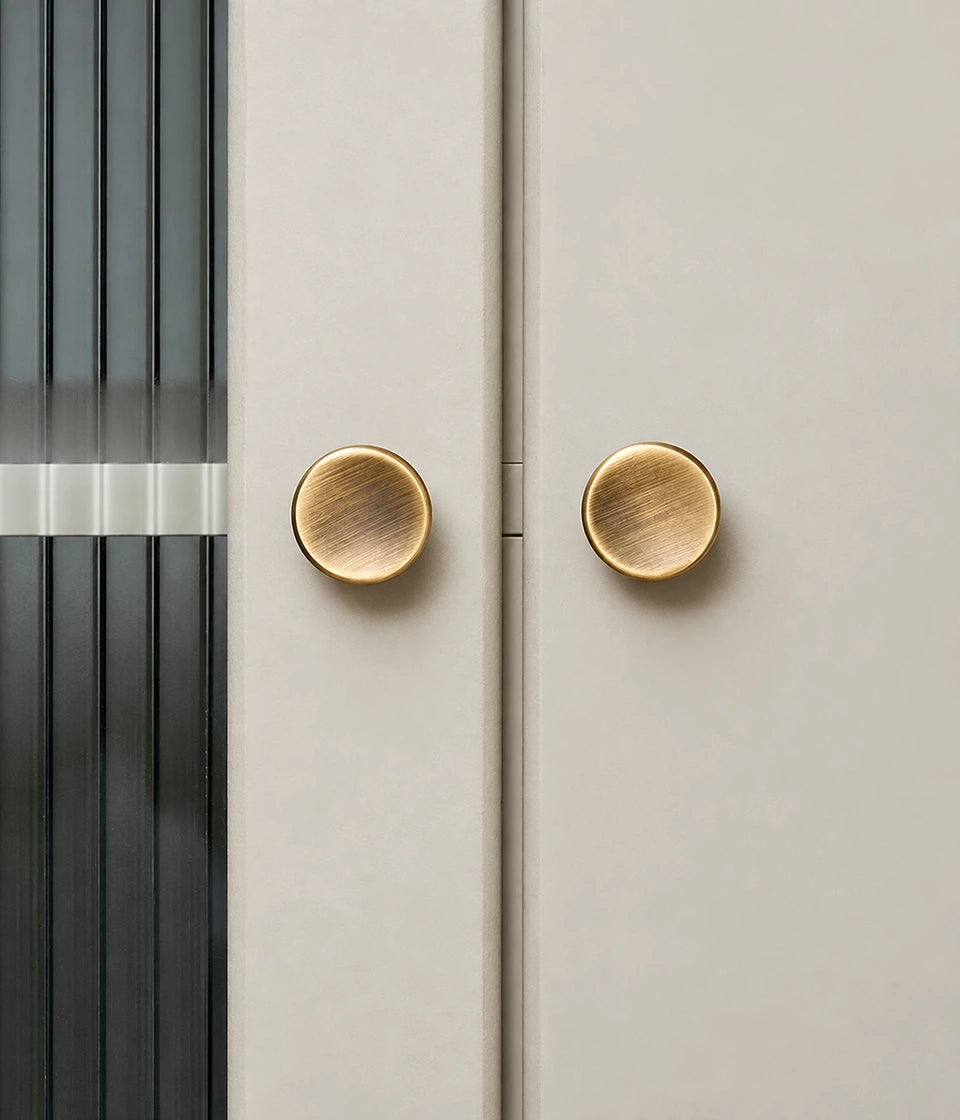 Antique brass dished round cabinet knobs fitted to light cabinet doors