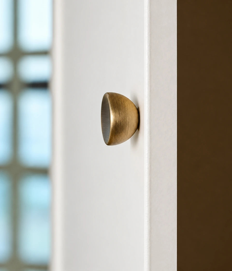 Side view of the rounded stemless antique brass cabinet knob