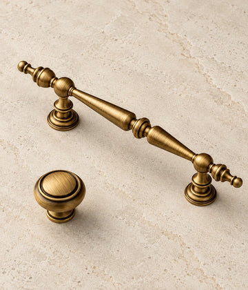 Antique Brass Double-Spindle Cabinet Pulls & Knob on warm ivory limestone