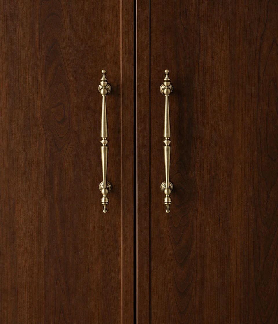 Antique brass double-spindle cabinet pulls installed vertically on dark wood doors