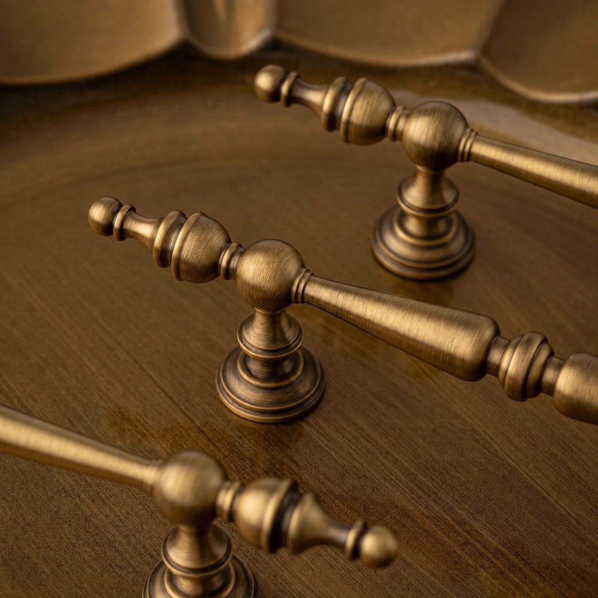 Close-up of antique brass spindle grip, ball-tipped finial and stepped mounting base