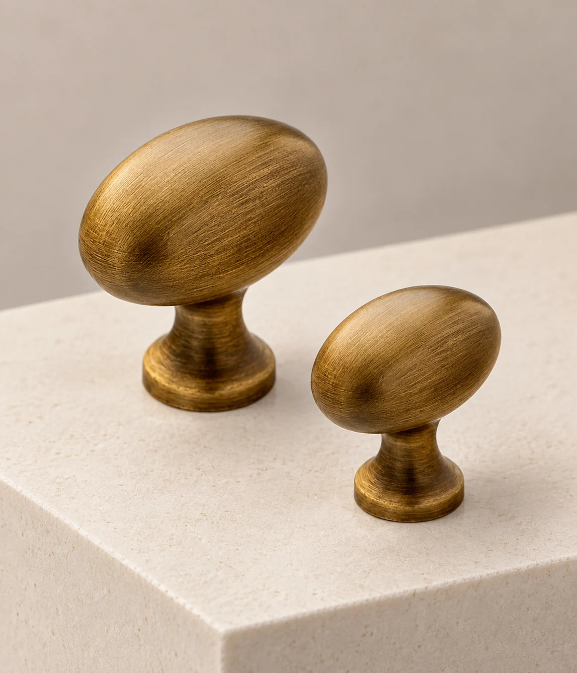 Smooth brushed antique brass egg knobs with waisted stems and round bases